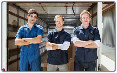 three men, arms crossed, in front of truck with open back